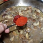 na patelni smażą się pokrojone pieczarki i drobno siekana cebula