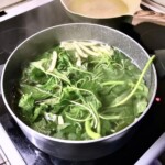 w garnku gotują się liście szpinaku