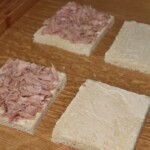 Tramezzini kromki chleba tostowego posmarowane majonezem i obłożone tuńczykiem z puszki