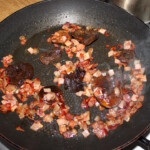 na patelni smaży się drobno siekany boczek oraz grzyby