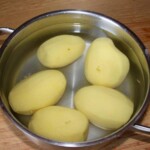 ziemniaki obrane w garnku z zimną wodą