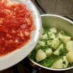 w garnku znajdują się pokrojone ziemniaki i groszek