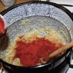 kapusta kiszona dusi się w dużym garnku razem z mieloną czerwoną papryką