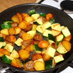 na patelni smażą się pokrojone ziemniaki oraz cukinia