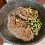 na patelni smażą się kotlety wieprzowe z siekaną dymką