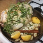 na patelni smaży się cały kurczak z ząbkami czosnku i kawałkami cytryny