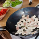 w woku smażą się małe kawałki piersi z kurczaka