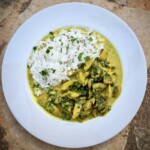 kurczak w sosie śmietanowym z pieczarkami na talerzu podany z ryżem