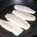 na patelni smażą się cztery filety z lab raksa skórą do dołu