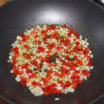w głębokiej patelni smażą się drobno siekane warzywa w oliwie