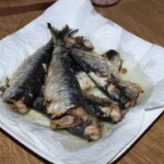 usmażone tuszki sardynek odciekają z tłuszczu na ręczniku papierowym