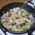 na patelni smażą się kapary, siekany fenkuł i smażone sardynki w kawałkach