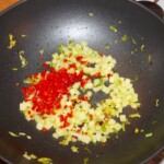 w woku smażą się drobno pokrojone seler naciowy oraz chili