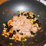w woku smażą się drobno pokrojone seler naciowy, chili oraz tuńczyk z puszki