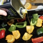 pokrojone w kostkę kolorowe papryki na blasze do pieczenia polewane są oliwą