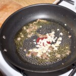 na patelni smaży się drobno siekana cebula oraz siekane fileciki anchois