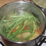 w garnku gotują się fasolka szparagowa zielona oraz ziemniaki i marchewka