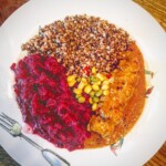 Roladki schabowe faszerowane serem feta na talerzu podane z kaszą gryczaną i surówką z kapusty czerwonej