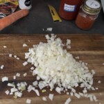 drobno siekana cebula na desce kuchennej
