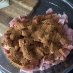 mięso pokrojone w małą kostkę posypane przyprawą w szklanej misce