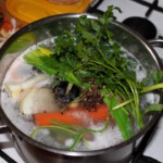 w garnku gotuje się rosół z kurczaka z warzywami