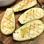 bakłażany przekrojone wzdłuż na połowę i ponacinane wewnątrz na krzyż