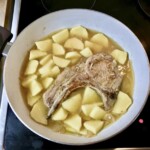 kotlet schabowy z kością dusi się na patelni razem z ziemniakami