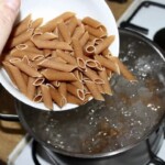 makaron razowy penne wrzucany jest do garnka z gotującą się wodą