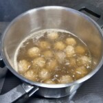 w garnku w bulionie gotują się pulpety po indoenzyjsku
