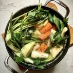 w dużym garnku gotuje się rosół z kurczaka z wielką ilością warzyw