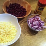 starty ser żółty w misce oraz czerwona fasola i siekana czerwona cebula w miskach