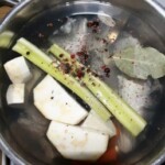 w garnku gotują się głowy i ogony ryb z warzywami