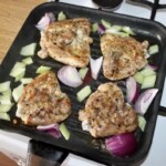 na patelni smażą się cztery udka z kurczaka z warzywami