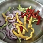 na patelni smażą się paski kolorowych papryk