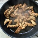 na patelni smażą się paski piersi z kurczaka