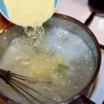 wsypywanie polenty do garnka z gotującą się wodą