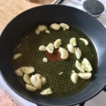 obrane ząbki czosnku smażą się na oliwie na patelni