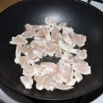 w woku smażą się małe paski mięsa z kurczaka