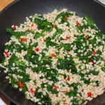 na patelni praży się kasza pęczak razem z liśćmi szpinaku