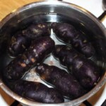 w garnku gotują się fioletowe ziemniaki