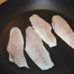 cztery filety z kurka smażą się na patelni