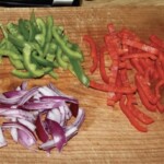 pokrojone w paski kolorowe papryki i czerwona cebula