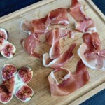 plastry szynki dojrzewającej i rozdarte figi