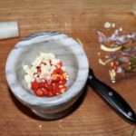 w moździerzu znajdują się papryczki chilli i czosnek