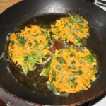 Placki z marchewki ze świeżym szpinakiem smażenie na patelni