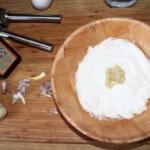 jogurt grecki w drewnianej misce razem ze zmiażdżonym czosnkiem