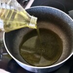 wlewanie oliwy do garnka na ogniu