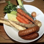 obfita jarzyna oraz kiełbasa śląska w dużej białej misce