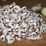 pokrojone drobno pieczarki leżą na desce kuchennej