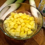 obrane i pokrojone w kostkę ziemniaki znajdują się w szklanej misce z wodą